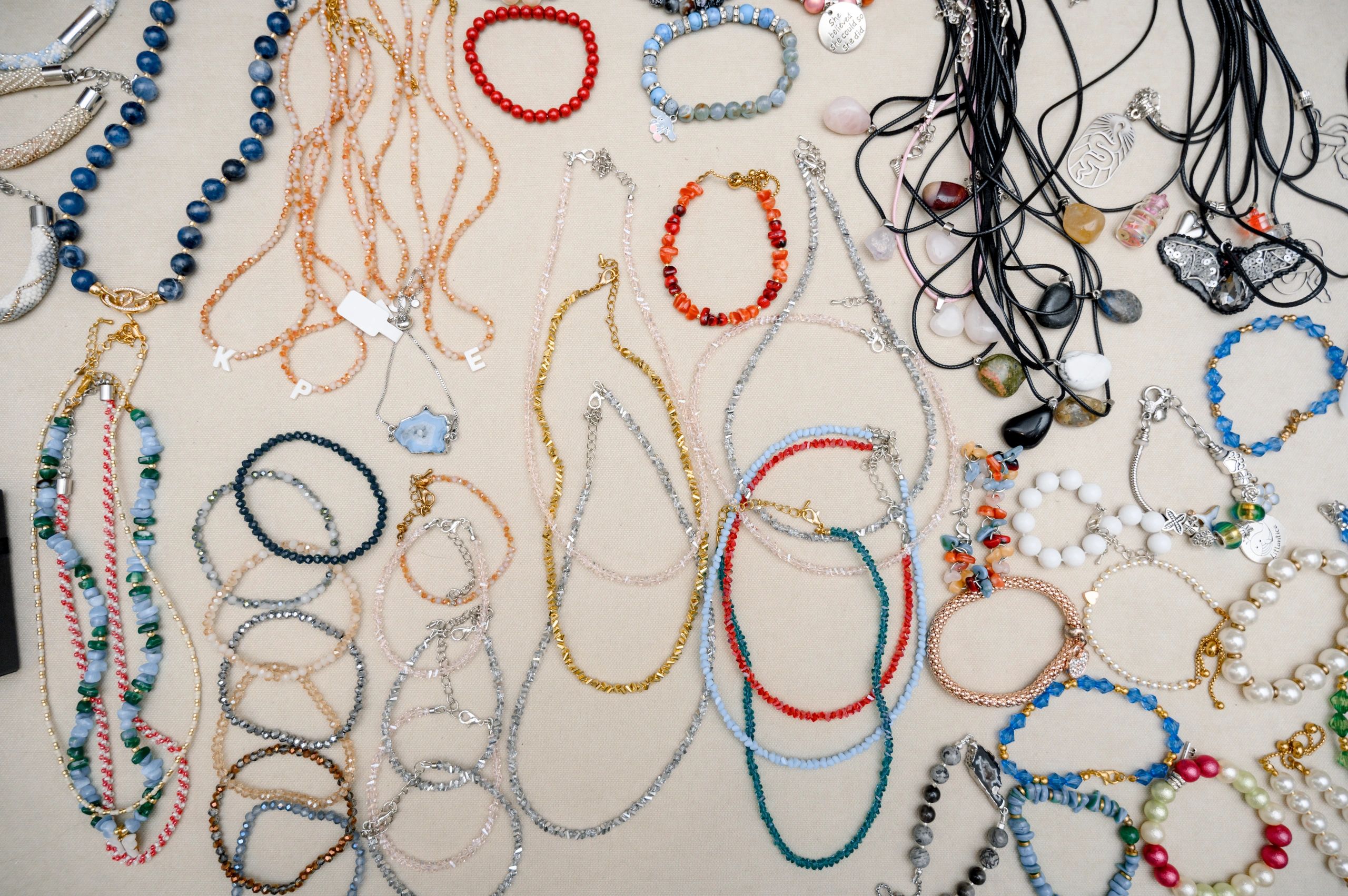 Assorted handmade jewelry displayed on a neutral background